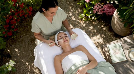 Esthetician applying enzyme facial mask in spa room